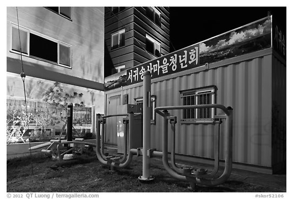 Public exercise equipment and buildings at night, Seogwipo. Jeju Island, South Korea (black and white)