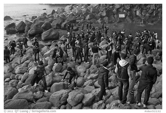 Crowd on rocky beach, Seogwipo. Jeju Island, South Korea (black and white)