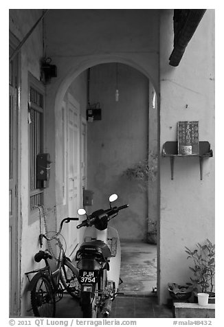 Motorcycle and altar outside townhouse. George Town, Penang, Malaysia (black and white)