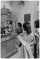 Holy man distributes fire to women, Sri Mariamman Temple. George Town, Penang, Malaysia (black and white)