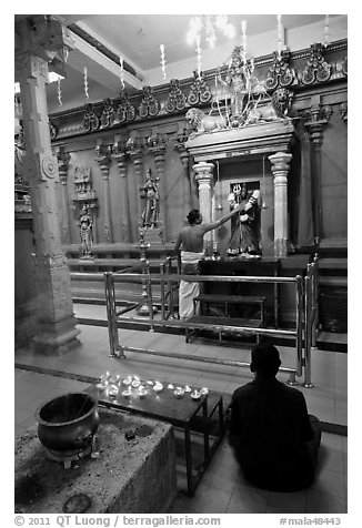 Holy man tends to altar, Hindu temple. George Town, Penang, Malaysia