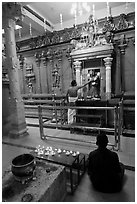 Holy man tends to altar, Hindu temple. George Town, Penang, Malaysia (black and white)