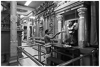 Holy man lights altar inside Sri Mariamman Temple. George Town, Penang, Malaysia (black and white)