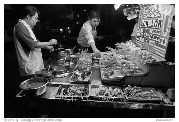 Men arranging skewers on hawker stall. George Town, Penang, Malaysia