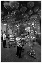 Worshiping inside goddess of Mercy temple. George Town, Penang, Malaysia (black and white)