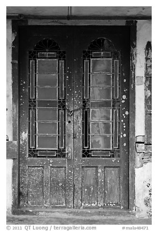 Old green door locked with chain. George Town, Penang, Malaysia (black and white)