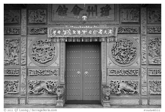 Red door and slate carved wall, Hainan Temple. George Town, Penang, Malaysia (black and white)