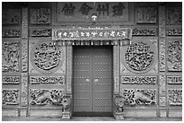 Red door and slate carved wall, Hainan Temple. George Town, Penang, Malaysia (black and white)