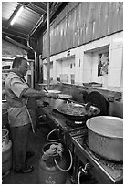 Man frying food in large pan. George Town, Penang, Malaysia (black and white)