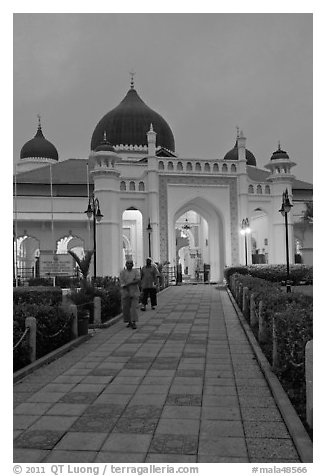 Men walking out of Masjid Kapitan Keling at dawn. George Town, Penang, Malaysia (black and white)