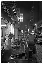 Cooks preparing food on Chinatown street at night. Kuala Lumpur, Malaysia (black and white)