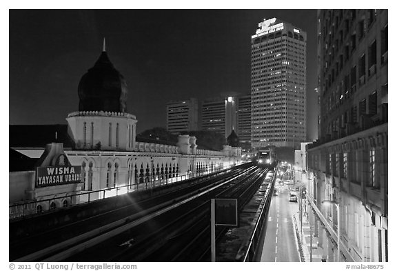 LRT train and tracks in front of Panggung Bandaraya at night. Kuala Lumpur, Malaysia (black and white)