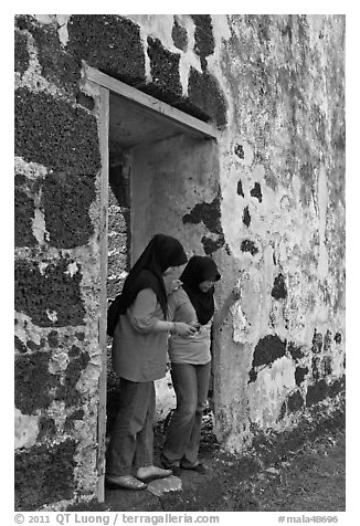 Malay girls exit on St Paul church doorway. Malacca City, Malaysia