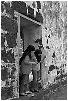 Malay girls exit on St Paul church doorway. Malacca City, Malaysia (black and white)