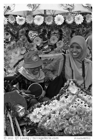 Mother and child riding decorated trishaw. Malacca City, Malaysia (black and white)