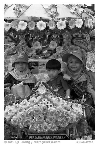 Malay children riding on trishaw. Malacca City, Malaysia (black and white)