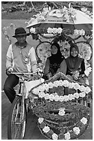 Rider and two women passengers, bicycle rickshaw. Malacca City, Malaysia (black and white)