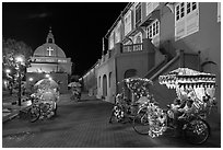 Illuminated trishaws on Town Square at night. Malacca City, Malaysia (black and white)