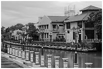 Lamps, riverside houses and St Peters Church towers. Malacca City, Malaysia (black and white)