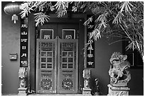 Chinese house entrance with lion sculpture and lanterns. Malacca City, Malaysia (black and white)