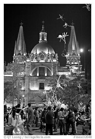 Children play with inflated balloons behind the Cathedral by night. Guadalajara, Jalisco, Mexico