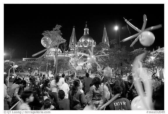 Children playing with ballons on Plaza de la Liberacion by night. Guadalajara, Jalisco, Mexico (black and white)