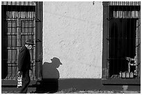 Elderly man walking along a colorful wall, Tlaquepaque. Jalisco, Mexico ( black and white)