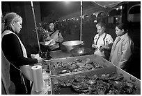 Women buying food at a food stand by night, Tlaquepaque. Jalisco, Mexico (black and white)