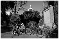 Men sitting in garden, with cathedral dome and ceramic monument, Tlaquepaque. Jalisco, Mexico (black and white)