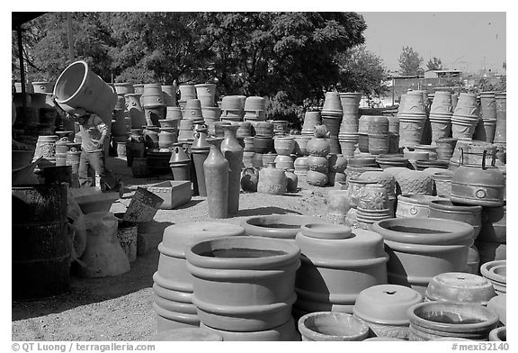 Pots for sale, with a man loading in the background, Tonala. Jalisco, Mexico (black and white)