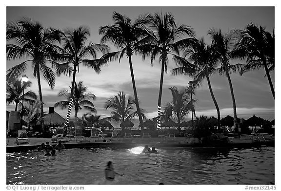 Palm-tree fringed swimming pool at sunset, Nuevo Vallarta, Nayarit. Jalisco, Mexico