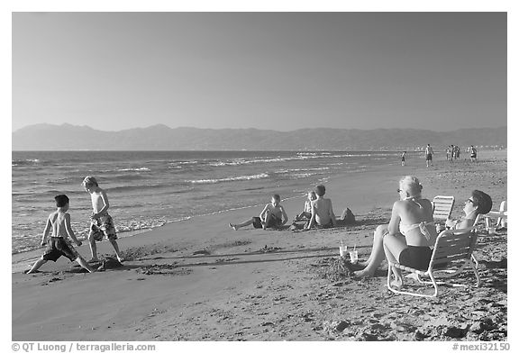 Mothers sitting on beach chairs watching children play in sand, Nuevo Vallarta, Nayarit. Jalisco, Mexico (black and white)