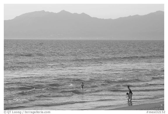 Woman holding children on the beach at sunset, Nuevo Vallarta, Nayarit. Jalisco, Mexico (black and white)