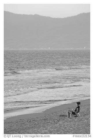 Woman sitting on the beach looking at the sunset, Nuevo Vallarta, Nayarit. Jalisco, Mexico