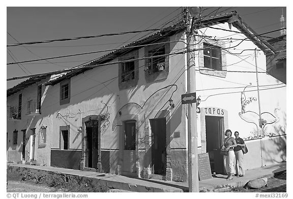 Two women outside of corner house with colorful door and window outlines, Puerto Vallarta, Jalisco. Jalisco, Mexico