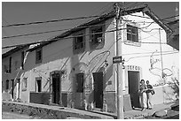 Two women outside of corner house with colorful door and window outlines, Puerto Vallarta, Jalisco. Jalisco, Mexico (black and white)