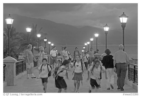 Children running on footbridge above Rio Cuale at dusk, Puerto Vallarta, Jalisco. Jalisco, Mexico (black and white)