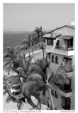 White adobe building with red tile roof,  palm trees and ocean, Puerto Vallarta, Jalisco. Jalisco, Mexico (black and white)