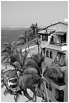 White adobe building with red tile roof,  palm trees and ocean, Puerto Vallarta, Jalisco. Jalisco, Mexico (black and white)