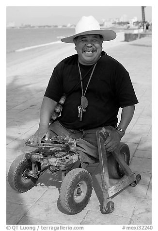 Man without legs  smiling on the Malecon, Puerto Vallarta, Jalisco. Jalisco, Mexico (black and white)