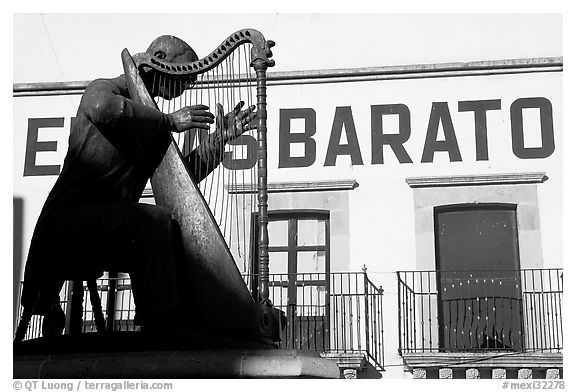 Statue of a musician and house with inscriptions. Zacatecas, Mexico (black and white)