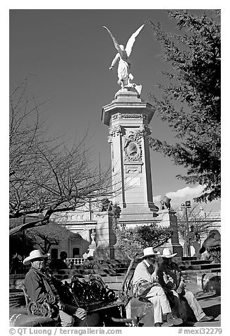 Men wearing cow-boy hats sitting in Garden of Independencia. Zacatecas, Mexico (black and white)