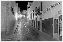 Uphill paved street by night with light trail. Zacatecas, Mexico (black and white)