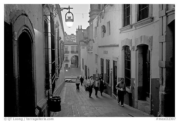 Children heading to school up a narrow cajaon, dawn. Zacatecas, Mexico