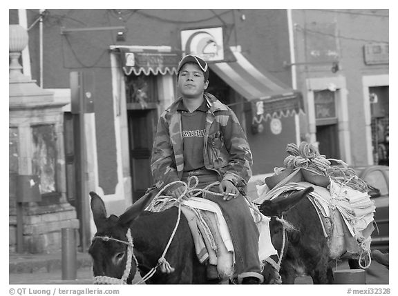 Young man riding a donkey in the streets. Guanajuato, Mexico (black and white)