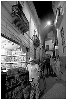 Man at a Newstand booth in a narrow callejone at night. Guanajuato, Mexico (black and white)