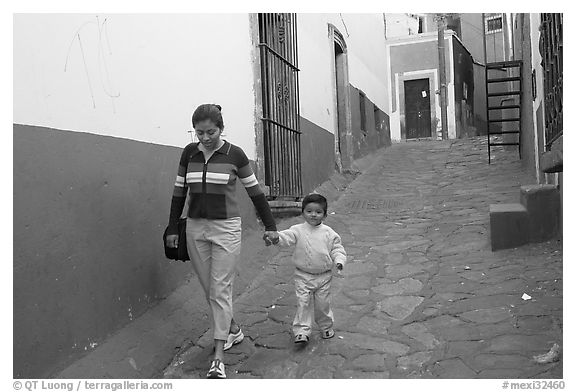 Woman and boy walking down an alleyway. Guanajuato, Mexico
