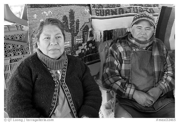 Couple sitting in front of carpets. Guanajuato, Mexico