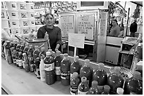 Woman at a booth with lots of chili bottles in Mercado Hidalgo. Guanajuato, Mexico (black and white)