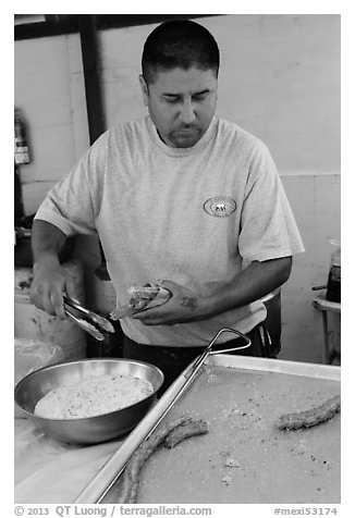 Man coating churros in sugar. Baja California, Mexico